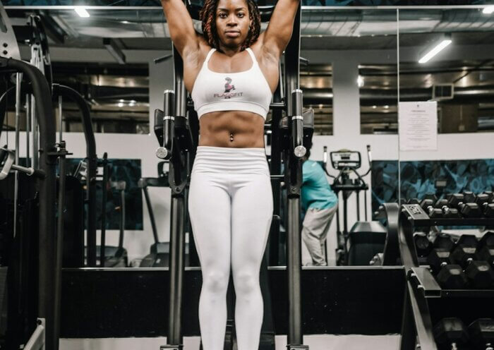 woman in white tank top and white pants doing exercise