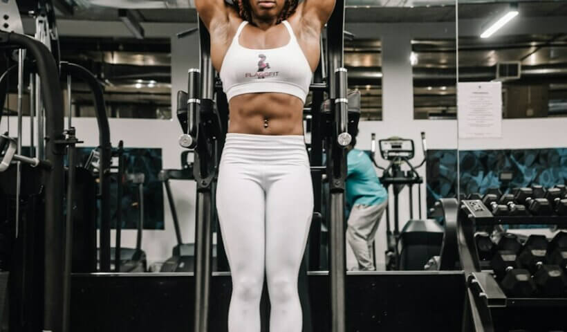 woman in white tank top and white pants doing exercise